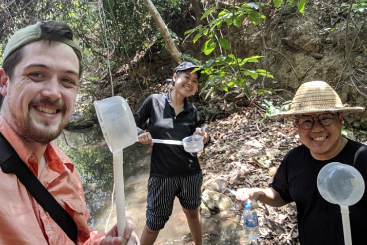 Chris Hayes (far left) works with collaborators in the field to conduct a mosquito larval survey.