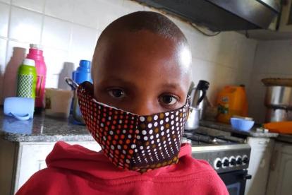 A pediatric oncology patient at Bugando Medical Centre wears a COVID-19 mask made of kitenge fabric.