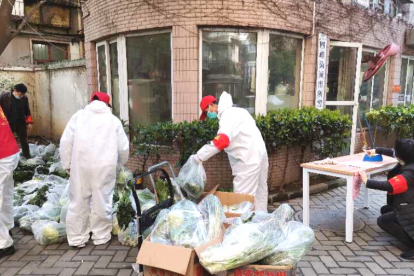 Workers, volunteers help deliver food to families in Wujan while most sheltered at home.