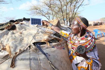 A woman connects a Bluetooth device to a solar unit