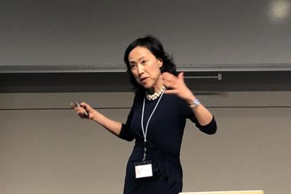 Thuy Le presenting on a stage