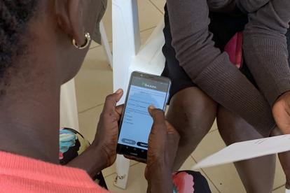 A study participant works with a partner to practice using the mSaada mobile application. Photo by Jacob Stocks.